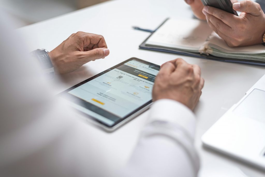 Close-up of professionals using a digital tablet and smartphone during a meeting.
